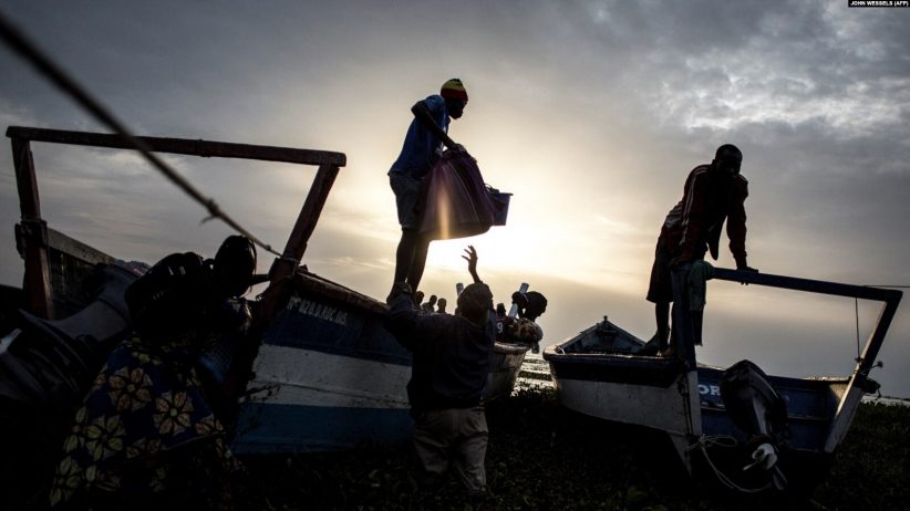 Des Congolais déplacés emballent des bateaux pour s'échapper sur le lac Albert vers l'Ouganda, le 5 mars 2018 à Tchomia.