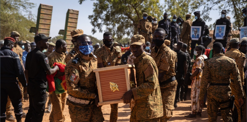 Des militaires burkinabè portent un cercueil d'un soldat dans la section militaire du cimetière de Gounghin à Ouagadougou le 23 novembre 2021, après la mort dudit soldat lors de l'attaque d'un camp de gendarmerie à Inata au Burkina Faso.